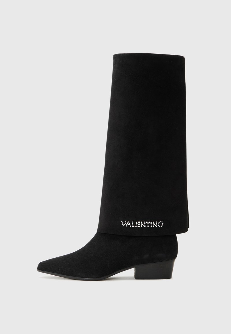 Bottines en suédine noire avec un bout pointu, un talon carré et un long revers. Présente un logo "Valentino" orné de cristaux sur un côté.