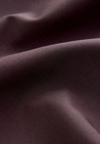 Textilie v hluboké švestkové barvě s hladkou texturou, která vykazuje jemné splývání a decentní lesk. Žádné vzory ani kovové prvky nejsou viditelné.