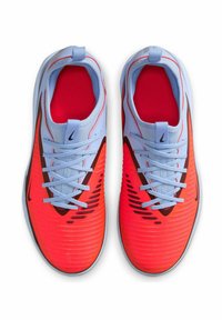 Zapatillas deportivas con una parte superior en coral brillante, diseño texturizado y acentos en azul claro. Presentan un cierre con cordones y un logo negro en el lateral.