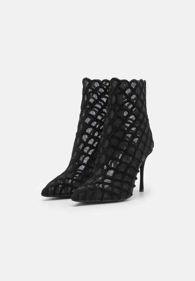 Botine negre cu un design din plasă transparentă, cu modele circulare, vârf ascuțit și toc stiletto. Textura de catifea sporește atractivitatea vizuală.