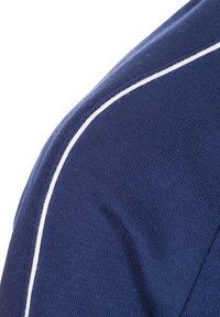 Tessuto di maglione blu navy con un motivo lavorato a maglia testurizzato. Presenta una striscia accentuata bianca lungo la cucitura della spalla, che mette in risalto il design.