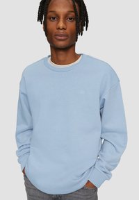 Lichtblauwe sweatshirt van zacht materiaal, met een ronde hals en mouwboorden. Klein logo op de borst, relaxte pasvorm.