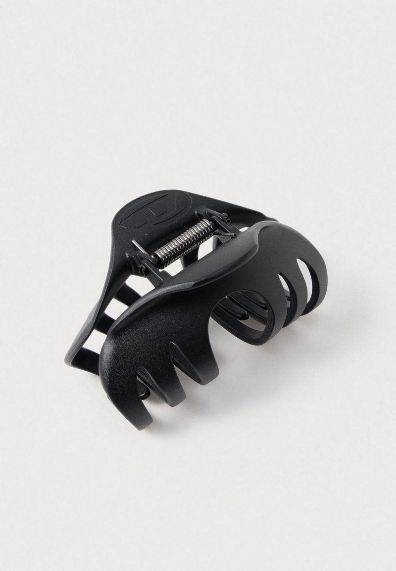 Schwarze Haarklammer aus Kunststoff mit einem gebogenen Design, mehreren Greifzähnen, einer Spiralfeder und offenen Ausschnitten für Flexibilität.