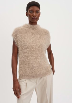 Beige Stricktop mit hohem Hals, kurzen Ärmeln und einer weichen, flauschigen Textur. Kombiniert mit hellen, plissierten Hosen.