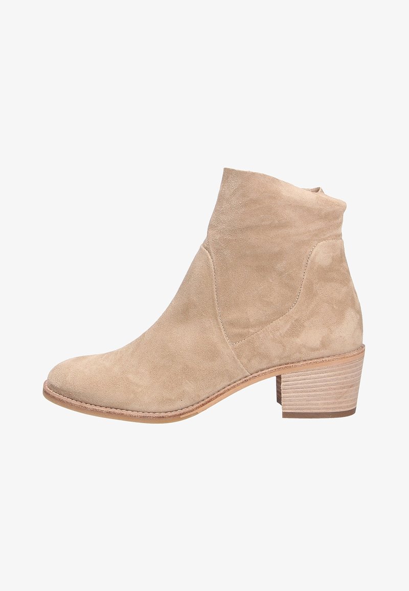 Stivale alla caviglia in suede beige con forma affusolata, tacco basso e impilato, e trama liscia. Presenta cuciture minime e colletto morbido.