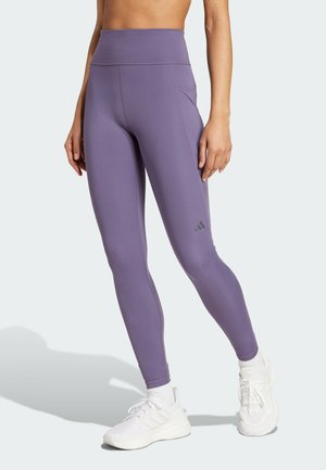 Lilla højtaljede leggings lavet af strækbart materiale, med flade sømme, en sidelomme og et lille brandlogo på den nederste del af benet.