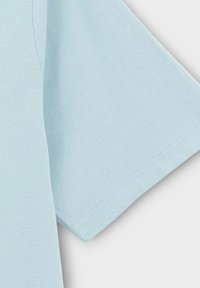 Lichtblauwe korte mouwen T-shirt gemaakt van zachte stof. Ronde halslijn met gestikte zoomdetails en een ontspannen pasvorm. Soepele textuur.