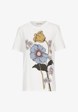 Maglietta bianca a maniche corte con grande grafica di fiori gialli, blu e rosa e foglie nere sulla parte anteriore.