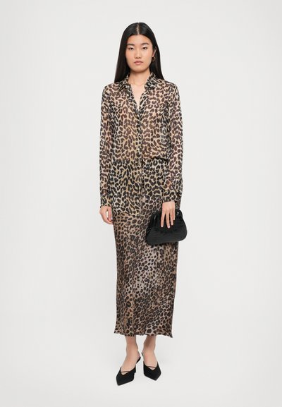 Leopard print maxi dress with long sleeves, semi-sheer fabric, collar, and a front button closure. Complemented by a black handbag and pointed flats.