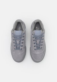 Gray suede sneakers with perforated detailing, flat gray laces, and a padded collar featuring the adidas logo on the tongue and insole.