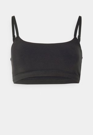 Bralette noire en tissu lisse, dotée de fines bretelles réglables, d'un décolleté arrondi et d'un design sans couture.