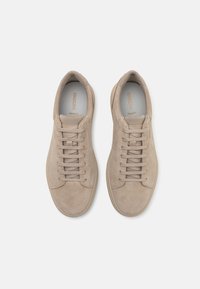 Baskets en daim beige avec fermeture à lacets à six œillets, bout rond et semelle en caoutchouc texturée, arborant le marquage 'GEOX Respira' à l'intérieur.