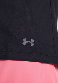 Schwarzer Sportstoff mit strukturiertem Finish, mit einem grauen Under Armour Logo und einem kontrastierenden rosa Saum am unteren Ende.