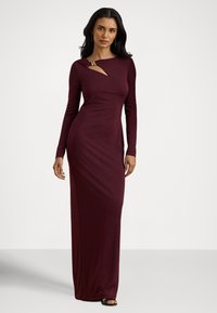 Bordo obleka z dolgimi rokavi, oprijete silhuete, s okrasnim zlatim poudarkom in asimetričnim izrezom na izrezu ovratnika.