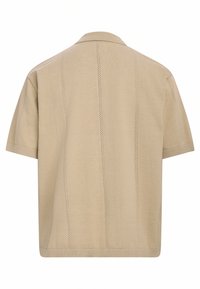 Beige kortermet skjorte med krage. Har subtile vertikale sømdetaljer og ribbede mansjetter, laget av et mykt tekstil.