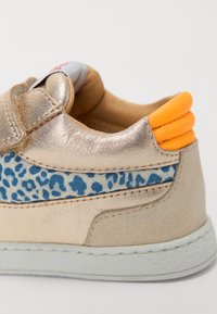 Baskets en cuir doré métallisé avec un panneau latéral imprimé léopard bleu et un accent orange sur le talon. Présente des détails brodés et une semelle en caoutchouc.