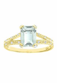 Anello d'oro con una pietra preziosa di colore azzurro a taglio smeraldo, affiancata da pietre più piccole e trasparenti su una fascia texturizzata.