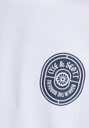Tissu blanc avec un petit logo ovale noir représentant une fleur au centre et le texte « LYLE & SCOTT BORN IN THE BORDERS » autour.