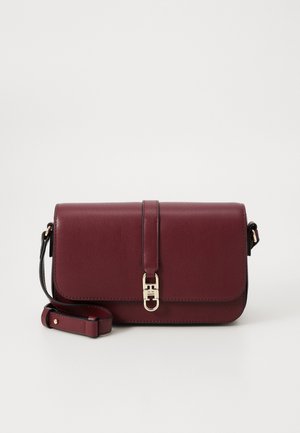 Prostokątna, ciemnoczerwona skórzana torebka na ramię z regulowanym paskiem i zapięciem na klapce z metalowym elementem w kolorze złota.