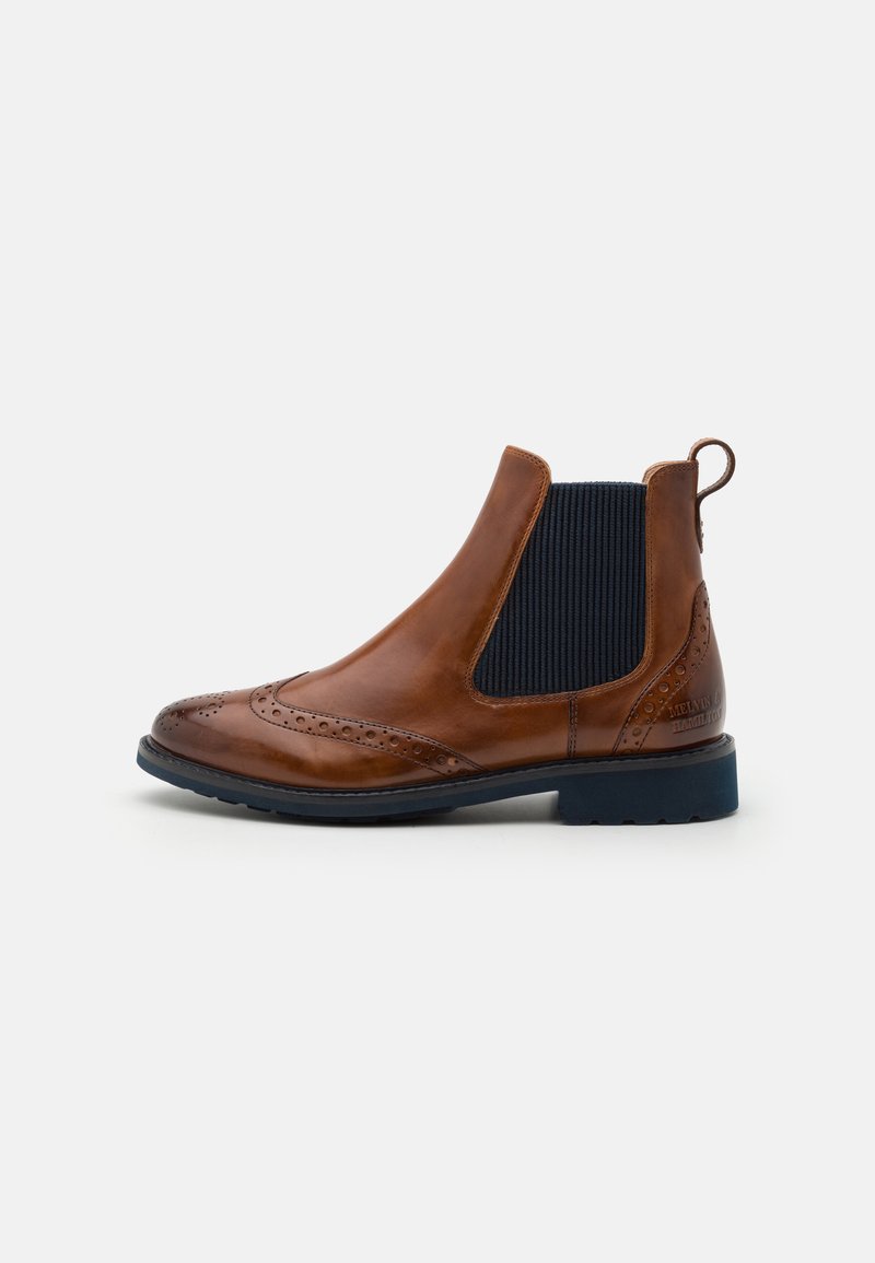 Bottines Chelsea en cuir marron avec des panneaux latéraux élastiques, un bout pointu, des détails brogues et une semelle bleue contrastante. Comprend une tirette pour un enfilage facile.