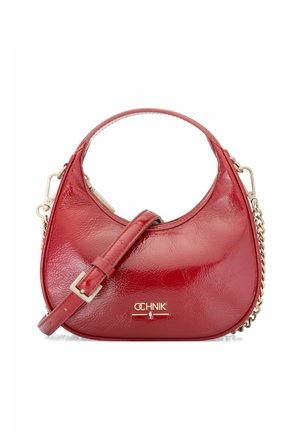 Czerwona, błyszcząca torebka w kształcie półksiężyca z górnym uchwytem, regulowanym paskiem, złotym łańcuszkiem oraz złotym logo marki na przodzie.