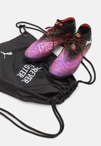 Football shoes with a black upper, orange accents, and a gradient purple pattern. Includes a black drawstring bag with white text.