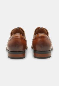 Pantofi de piele maro pentru bărbați, cu o textură netedă, tocuri rotunjite și detalii din lemn contrastante pe talpa și toc.