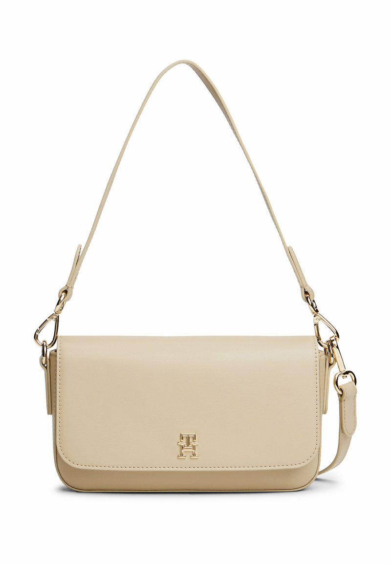 Beige Lederhandtasche mit Klappenverschluss, goldenen Hardware-Details und verstellbarem Schulterriemen. Verfügt über eine Logo-Verzierung auf der Vorderseite.