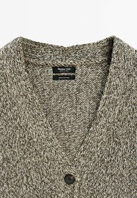 Cardigan en maille marbrée beige et marron avec col en V, un bouton visible et des étiquettes indiquant Massimo Dutti, fabriqué en Italie, 100 % coton.
