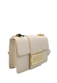 Borsa a tracolla in finta pelle beige con una placca logo in tono oro, tracolla a catena e chiusura a pattina. Texture liscia con dettagli cuciti.