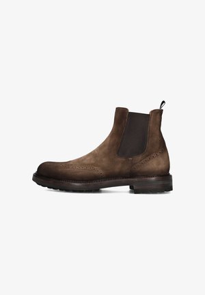 Bottines Chelsea en suede marron avec panneaux latéraux élastiques, détails brogues et semelle en caoutchouc. Comprend une languette pour un enfilage facile.