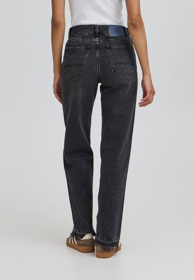 Crne traperice visokog struka s ravnim krojem, izgužvanim rubom i dva stražnja džepa. Ima plavi logo pečat na pojasu.