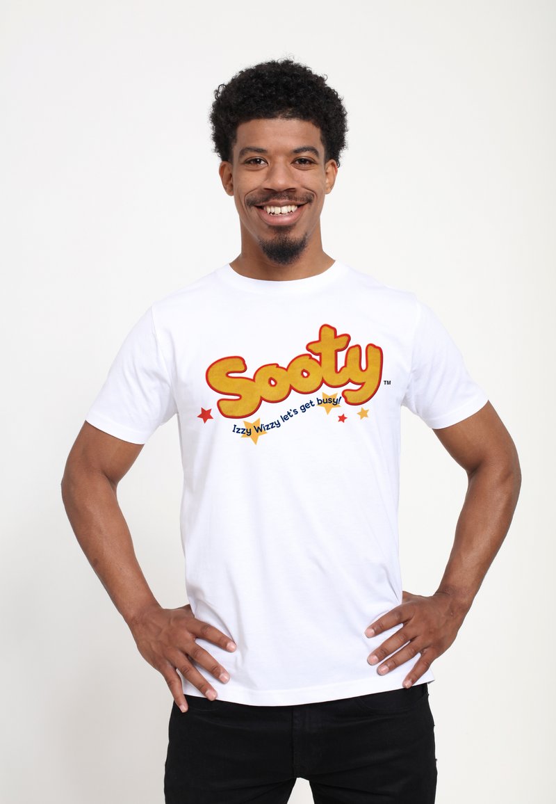 Hvid bomulds t-shirt med et farverigt "Sooty" grafik med rød og gul tekst, ledsaget af blå og gule stjerner, på en glat tekstur.