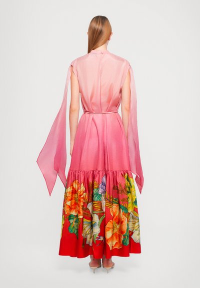 Vestido rosa con un escote alto y mangas fluidas, con un vibrante estampado floral en la falda roja y un dobladillo fruncido.