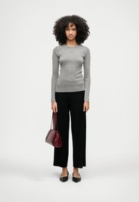Gray ribbed long-sleeve top, black wide-leg pants, black flats, and a burgundy handbag with a textured finish. Plain background.