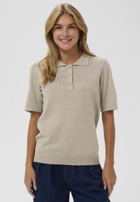 Béžový pletený polo top s krátkymi rukávmi, trojčlánkovou zapínaním a ribbovaným lemom. Hladká textúra s klasickým dizajnom goliera.