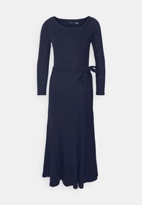Longue robe en maille bleu marine avec manches longues, encolure dégagée et lien à la taille sur le côté droit.