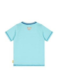 Camiseta de algodón de color azul claro con mangas cortas, que presenta un parche de oso en la parte posterior y costuras en azul de contraste a lo largo del escote y los dobladillos.