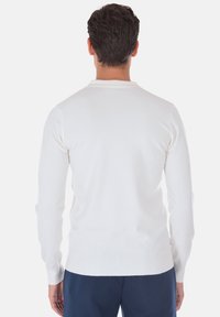 Maglione bianco a maniche lunghe, design aderente, texture liscia, collo a giro; visto da dietro, senza motivi o decorazioni evidenti.