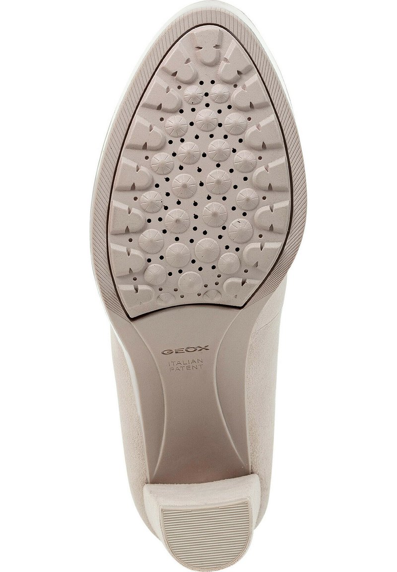 Die Geox-Schuhsohle zeichnet sich durch eine hellbeige Gummisohle mit runden, strukturierten Mustern und Perforationen zur Atmungsaktivität aus, die von einer glatten Kante akzentuiert wird.