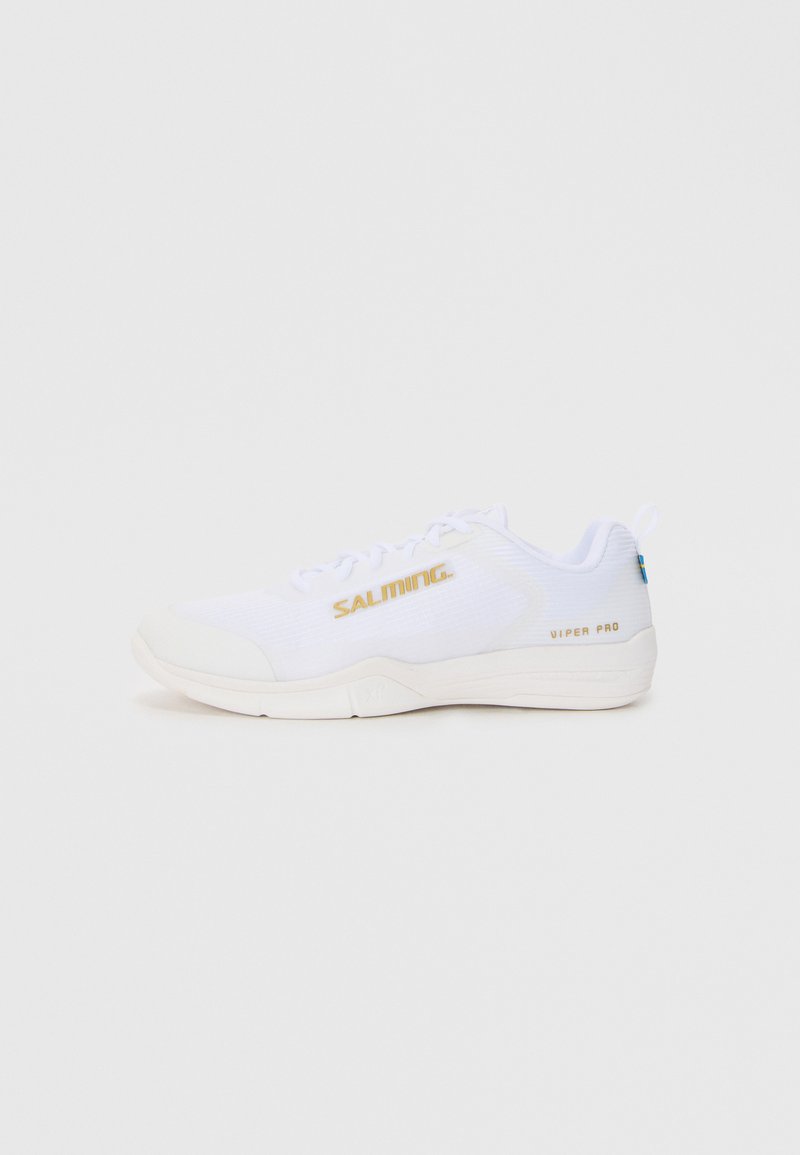 Baskets de sport blanches avec tige en mesh, arborant un logo doré "SALMING" sur le côté, semelle en caoutchouc et éléments de design minimalistes.