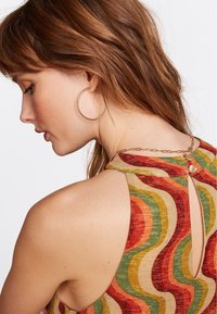 Ärmelloses Top in mehreren Farben mit einem wellenförmigen Muster in Rot, Grün und Gelb. Mit einem Schlüsselspalten-Rücken und goldenen Hardware-Details versehen.