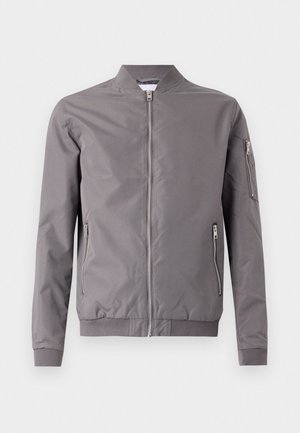 Gray bomber jacket made of smooth fabric. Features a zip front, side pockets, and a zippered arm pocket. Ribbed cuffs and hem.