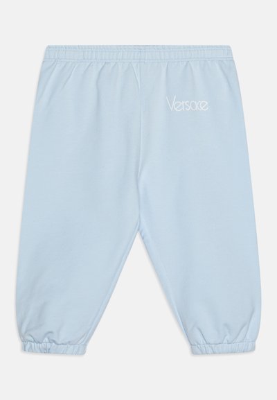 Ανοιχτό μπλε φόρμες με ελαστι κή μέση και μανσέτες, διακοσμημένες με το λογότυπο Versace κεντημένο σε λευκό στο αριστερό μηρό.