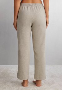 Hellgraue, lockere Sweatpants mit elastischem Bund, aus weichem Material gefertigt. Gerades Bein Design mit glatter Textur.