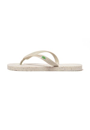 Chancla de goma beige moteada con correas texturizadas y pequeño logo verde y amarillo en la correa lateral.