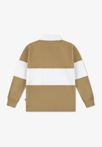 Polo à manches longues couleur sable avec une bande horizontale blanche. Il présente un col classique et des poignets côtelés. Texture en coton lisse.