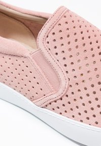 Růžová semišová nazouvací bota s perforovaným vzorem, elastickou postranní částí a bílou gumovou podrážkou.