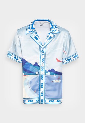 Chemise en soie à manches courtes avec une bordure feuillue bleue et blanche et une impression pittoresque d'une plage, de montagnes, de voiliers et d'avions dans le ciel.
