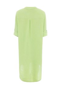 Robe chemise verte claire, longueur genoux, fabriquée en tissu texturé. Présente des manches retroussées, une plis au dos et un col pour un ajustement décontracté.